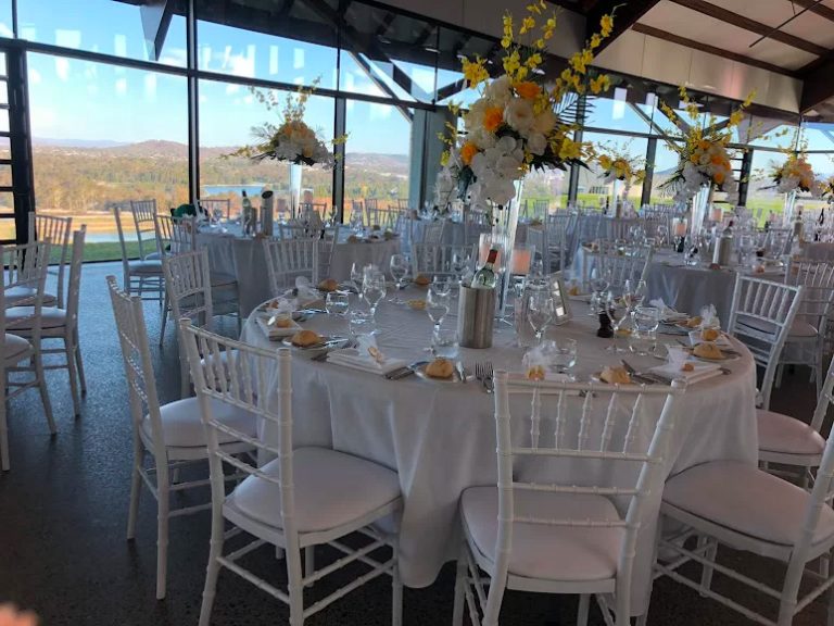 white tiffany chairs around white banquet tables for a wedding reception