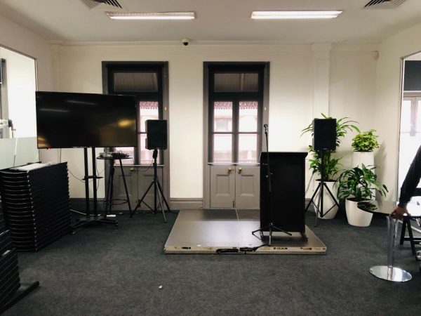 presentation set up with microphone and lectern with tv and speakers
