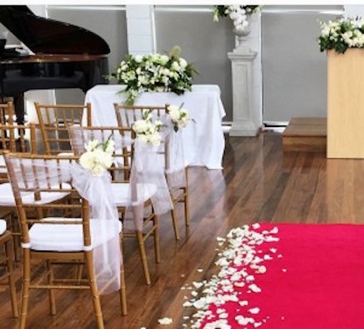 wedding ceremony set up with red carpet and tiffany chairs