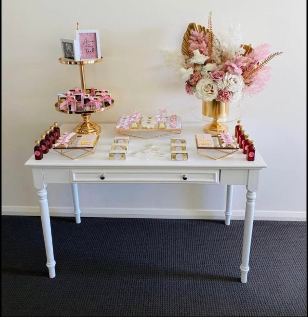 white vintage style table with an assort of decorations placed on top