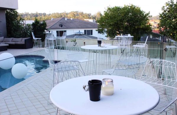 backyard party with white wire cocktail tables and white wire stools 