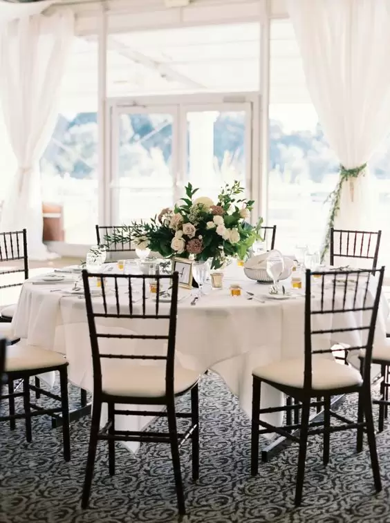 black tiffany chairs with white cushions for a wedding reception