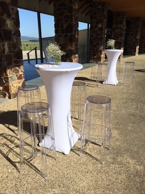 outdoor event set up with clear ghost stools and white lycra sock cocktail table