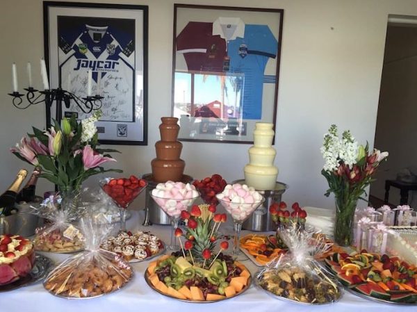 dessert table with 2 chocolate fountains, fruit platters and sweets