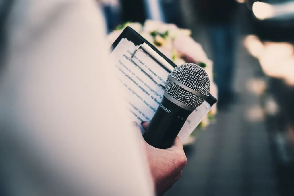 person holding a clipboard and a microphone